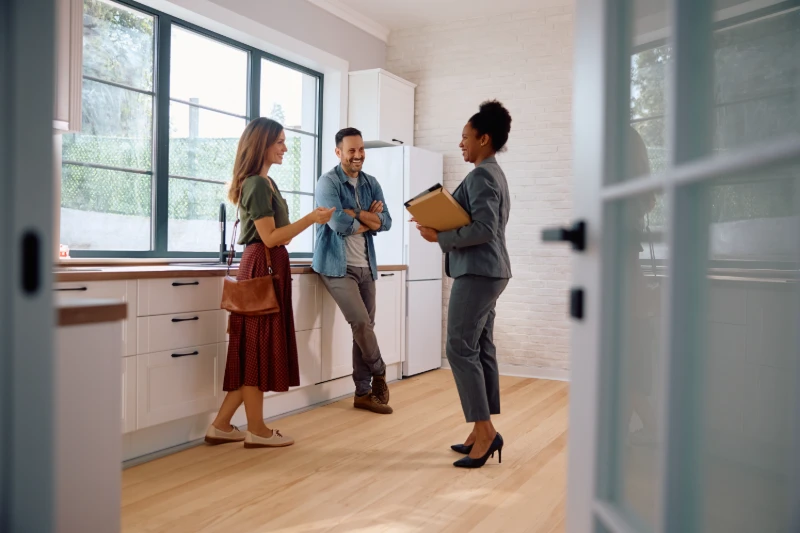 Happy couple talking with a real estate agent