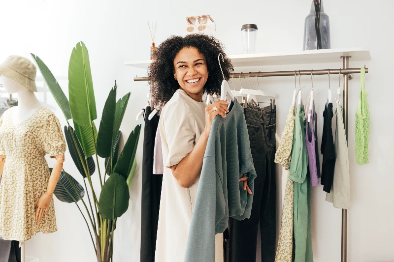 Laughing woman customer choosing sweatshirt